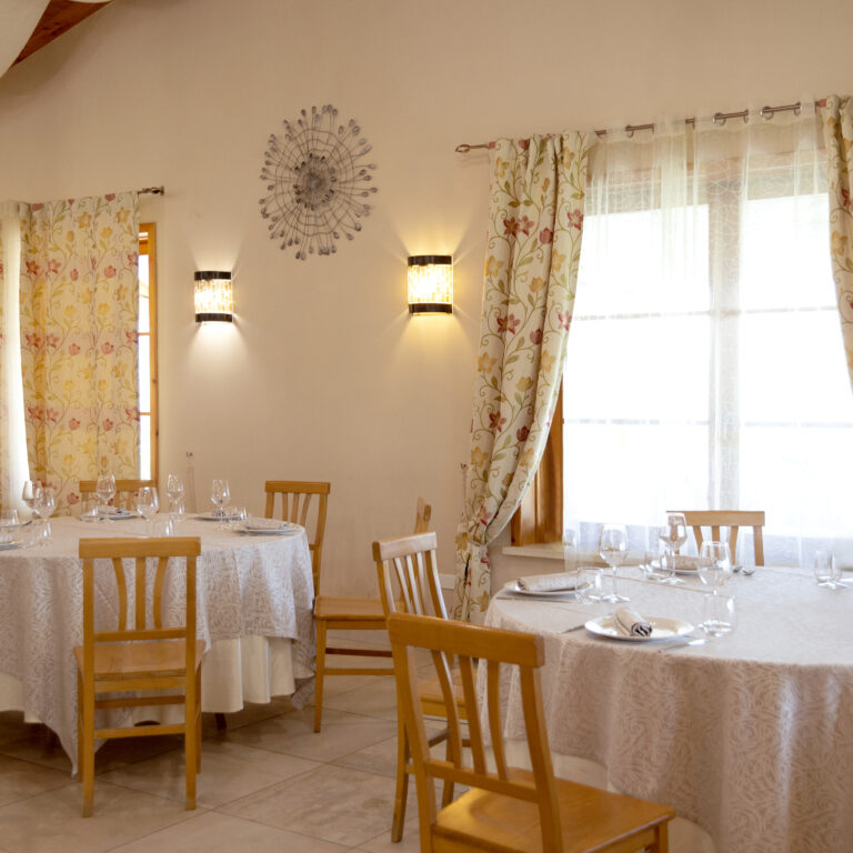 Sala interna dell'agriturismo con tavoli rotondi